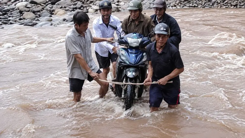 Giáo viên vùng biên Nghệ An vượt suối, cùng người dân khiêng xe máy qua dòng nước xiết để đến điểm trường. Xem hình ảnh xúc động.