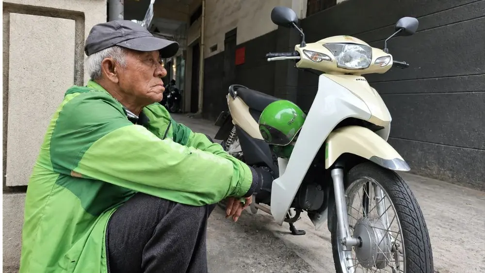 Tài xế xe ôm 89 tuổi Trần Văn Sanh vẫn miệt mài mưu sinh tại TP.HCM dù tuổi cao và ngày càng khó đón khách.