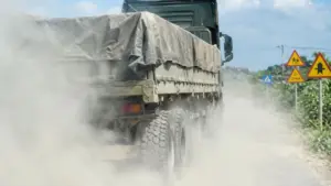 Bụi phủ trắng Quốc lộ 7 đoạn qua xã Yên Xuân, Nghệ An, khi xe cộ đi qua khu vực đang thi công, ảnh hưởng đến sinh hoạt người dân.