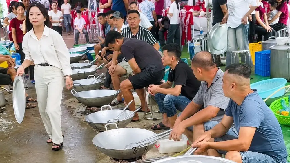Hàng chục nam giới ở thôn Thủy Trầm, xã Tiên Lương, tỉnh Phú Thọ, cùng nhau sơ chế, nấu nướng, xào thức ăn để phục vụ hơn 100 mâm cỗ trong đám cưới của một gia đình.