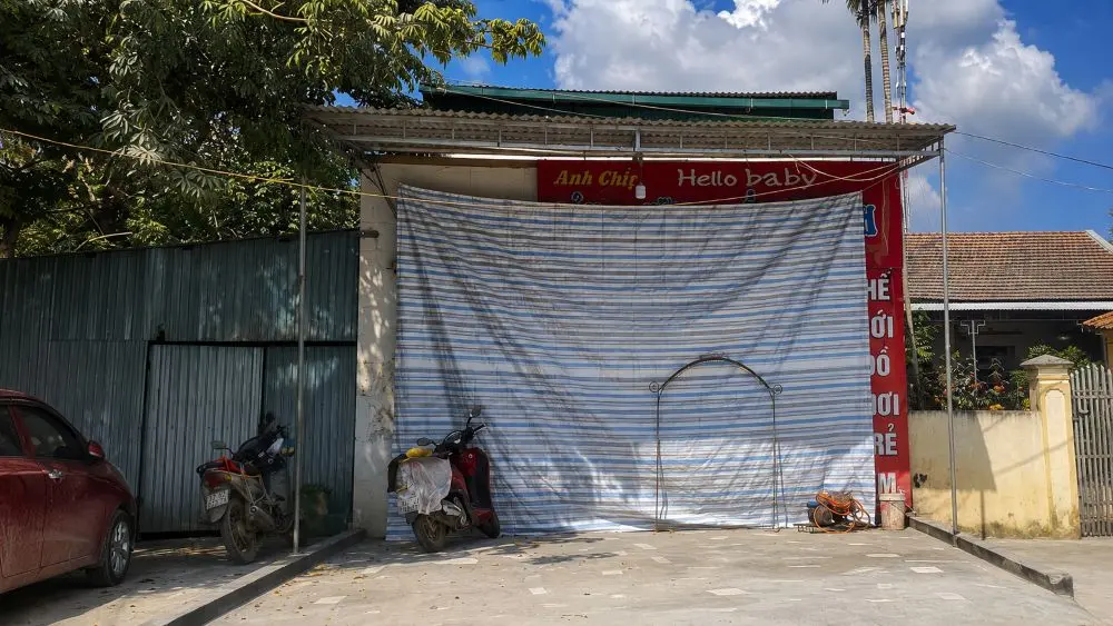 Bụi từ công trình sửa chữa Quốc lộ 7 khiến người dân dọc tuyến đường phải che chắn trước nhà để hạn chế bụi bay vào không gian sinh hoạt.