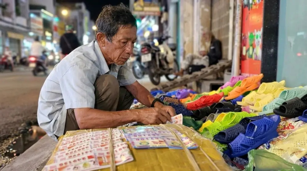 Người đàn ông 62 tuổi ở TP.HCM bán dép bên lề đường để kiếm thêm thu nhập, thu hút khách hàng dừng xe nhiều vòng tìm mua.