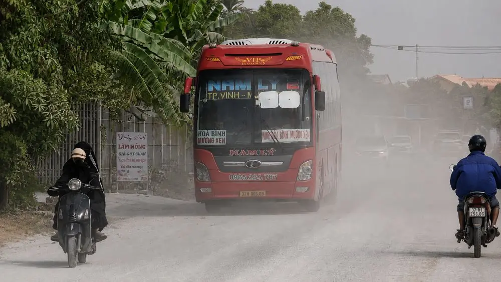 Bụi mù mịt trên Quốc lộ 7, Nghệ An khi xe tải lớn đi qua đoạn đường thi công, khiến tầm nhìn của người tham gia giao thông bị hạn chế.